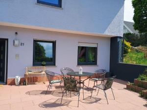 a patio with a table and chairs in front of a house at Ferienwohnung Mobembo in Konz