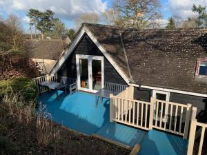 a house with a blue deck with a bench on it at The Pightle Annexe in Saffron Walden