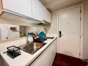 a kitchen with a sink and a counter top at Makati Business District Prime Accommodations in Manila
