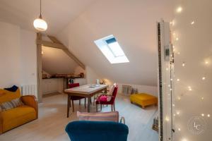een woonkamer met een tafel, stoelen en een bank bij L'Artiste - 60 m - 1 Bedroom in Orléans