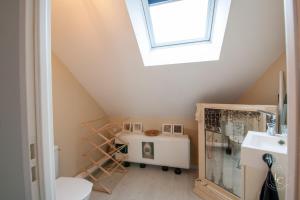 een badkamer op zolder met een wastafel en een dakraam bij L'Artiste - 60 m - 1 Bedroom in Orléans +10 foto's