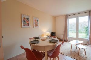 アルドンにあるLa Golfette - Cottage 2 personnesのテーブルと椅子と窓のあるダイニングルーム