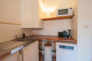 アルドンにあるLa Golfette - Cottage 2 personnesのシンクと電子レンジのある小さなキッチン