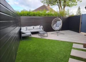 a patio with a wicker chair and a wicker rattan chair at Trendy Studio With A Private Garden in Chatham