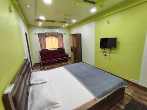 a bedroom with a large bed and a red couch at Kalwars Millennials Park in Karjat