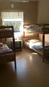 a room with three bunk beds and a window at Täljebo Vandrarhem, Sundsbrovägen 1, Söderhamn in Söderhamn