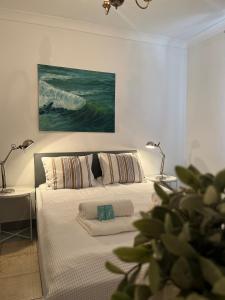 a bedroom with a bed with two lamps and a painting at Pod Różą Economy in Łeba