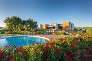 ein Swimmingpool in einem Garten mit Blumen in der Unterkunft Papafigo Glamping in Vodnjan