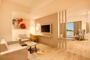 a living room with a couch and a tv at Lemon Tree Hotel, Jamnagar in Jamnagar