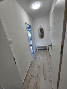 a hallway with white walls and wooden floors and a mirror at Apartment an der Weser in Bremerhaven +37 photos