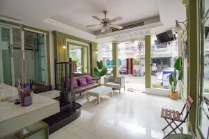 a living room with a couch and a ceiling fan at Skutan Inn Sutthisan Nexus Opal in Bangkok