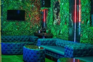 una sala de estar con sofás azules y una pared verde en Green Mansion, en Domneşti