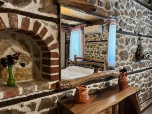 a bedroom with a bed in a stone wall at Vechia Villa Mitllari in Tushemisht