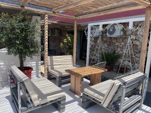 un patio con sedie e tavolo e sedie in legno di Opera Vama Veche a Vama Veche