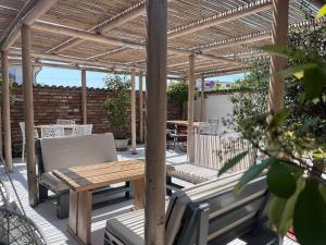 un pergolato in legno con tavolo e sedie in legno su un patio di Opera Vama Veche a Vama Veche