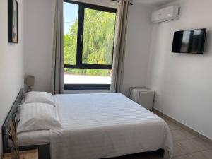 una camera da letto bianca con un letto e una finestra di Opera Vama Veche a Vama Veche
