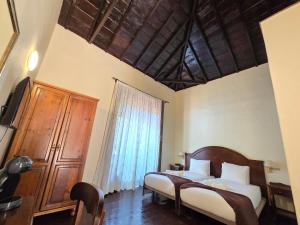 a bedroom with a bed and a large window at Tamahuche Hotel Rural in Vallehermoso