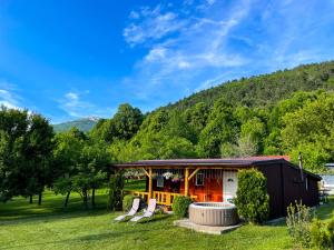 Home La Sierra with WHIRLPOOL BATH for two في كورينيتسا: منزل به شرفة وكراسي في العشب