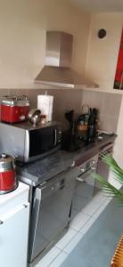 a kitchen with a stove and a microwave at Maison rue Sonia Delaunay LE MANS in Le Mans
