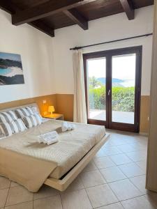 a bedroom with a large bed with a large window at Villa Blue Horizon in Costa Paradiso