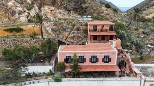 an aerial view of a house with a mountain at Tamahuche Hotel Rural in Vallehermoso