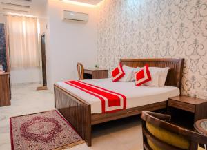 a bedroom with a bed with red and white pillows at Peepal Tree Residency in New Delhi +106 photos