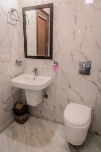 a white bathroom with a sink and a toilet at Peepal Tree Residency in New Delhi