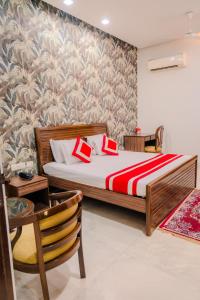 a bedroom with a bed with a red and white bedspread at Peepal Tree Residency in New Delhi