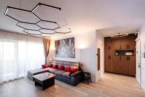 Una sala de estar con un sofá y una lámpara de araña. en Park View Residence, en Bucarest