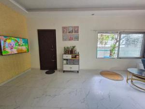 un soggiorno vuoto con tavolo e porta di Charming Green Hideout a Pune