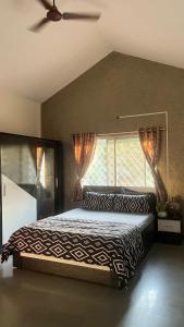 una camera da letto con un letto e una finestra di Charming Green Hideout a Pune