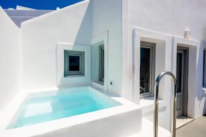 Casa blanca con balcón con piscina en Ilioperato Hotel, en Imerovigli