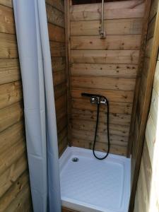 a shower with a hose in a wooden bathroom at Emplacement pour tente in Saint-Laurent-du-Plan