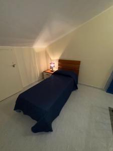ein Schlafzimmer mit einem Bett und einem Nachttisch mit einer Lampe in der Unterkunft Roberto's Apartment in Piedimonte San Germano + 8 Fotos