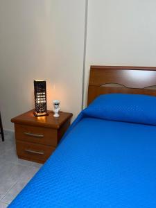 ein Schlafzimmer mit einem blauen Bett und einem Nachttisch in der Unterkunft Roberto's Apartment in Piedimonte San Germano