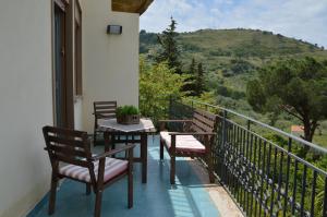 - un balcon avec deux bancs et une table avec vue dans l'établissement Villa Bouganvilla, à Cefalù