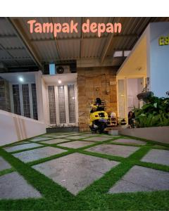 ein gelbes Motorrad in einem Raum mit Gras geparkt in der Unterkunft Villa kayana E8 Batu in Karangploso