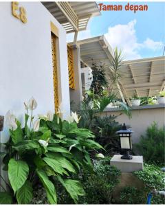 eine Veranda eines Hauses mit Blumen und einer Laterne in der Unterkunft Villa kayana E8 Batu in Karangploso
