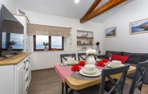 a kitchen and dining room with a table and a television at Beautiful Casa Dea with pool in Opatija in Ičići