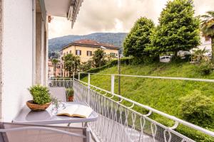 a book on a table on a balcony with a view at Lake Bike Station - Central Baveno - Free WiFi in Baveno