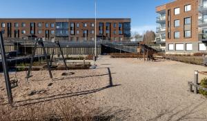 an empty playground in a city with buildings at Metsämansikan helmi I Free parking & Netflix I 5G in Espoo