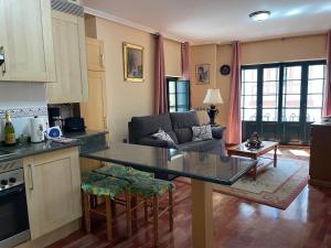 a kitchen and living room with a table and a couch at La nueva Covadonguina in Cangas de Onís