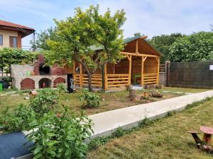 a wooden cabin in a garden with a tree at Casa Călin in Vama Veche