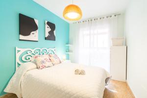 Un dormitorio con una cama blanca con una pared azul. en Playa de Levante, Céntrico y Parking - by Aloha Palma, en Águilas