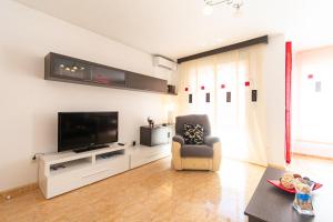 sala de estar con silla y TV de pantalla plana en Playa de Levante, Céntrico y Parking - by Aloha Palma, en Águilas