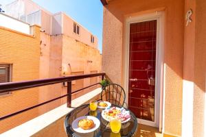 Una mesa con comida y bebidas en un balcón. en Playa de Levante, Céntrico y Parking - by Aloha Palma, en Águilas
