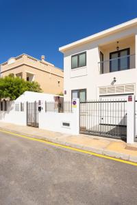 a white fence in front of a house at Casa Malo Garden and sea view townhouse in La Jaca