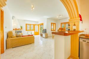 a kitchen and living room with a couch and an archway at Villa Mona - PlusHolidays in Ifach