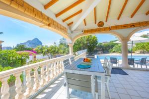 a balcony with a table and chairs and a pool at Villa Mona - PlusHolidays in Ifach