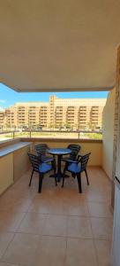 einen Balkon mit einem Tisch und Stühlen sowie einige Gebäude in der Unterkunft Costa Caribe II Nº 1028 in Oropesa del Mar